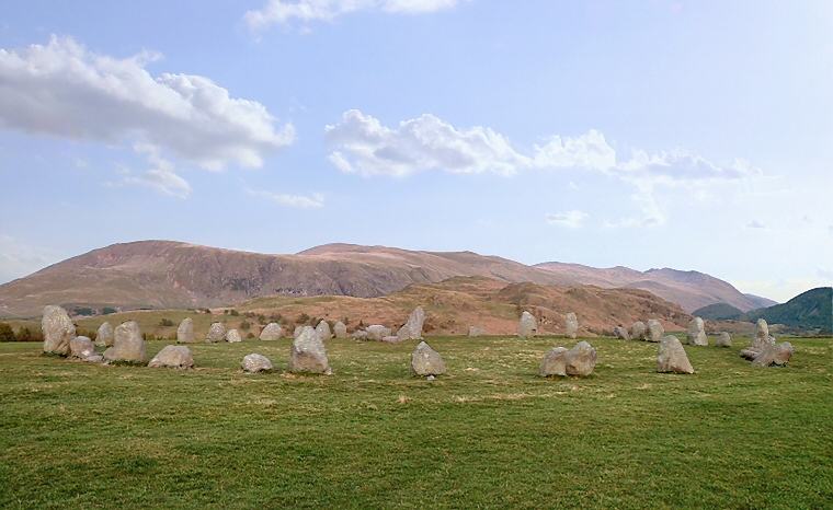 Castlerigg stone circle looking southeast with from left to right, the hills of Clough Head, Great Dodd, Watson's Dodd, Stybarrow Dodd, Raise and Helvellyn on the horizon and with Low Rigg and High Rigg the lower range immediately beyond the circle and finally Great How which stands at the head of Thirlmere and the edge of the Castlerigg Fells being the darker hills to the right of the picture. The entrance to the circle is marked by the tall stone on the left